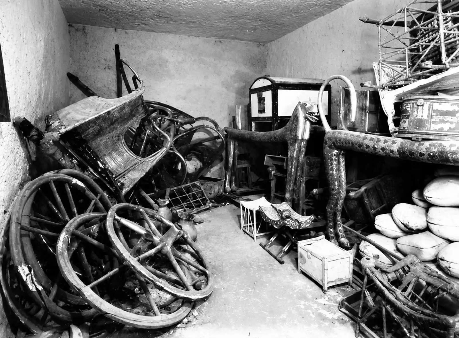 Předsíň Tutanchamonovy hrobky zachycená fotografem Harrym Burtonem krátce po jejím otevření. Archeologové zde objevili stovky cenných předmětů včetně rozložených obřadních vozů. Foto: Harry Burton.